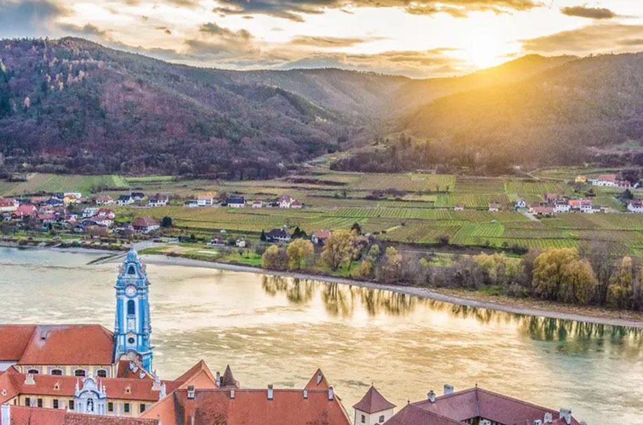 Sunset over the Danube in the Wachau valley with a river town below the hills